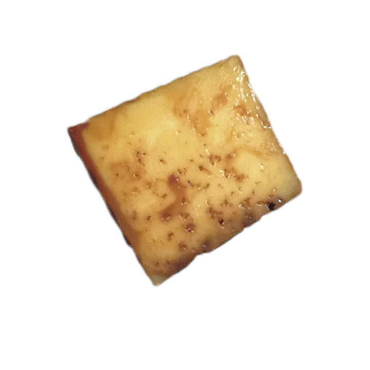 Cuña de queso curado con vetas de color ámbar, ahumado